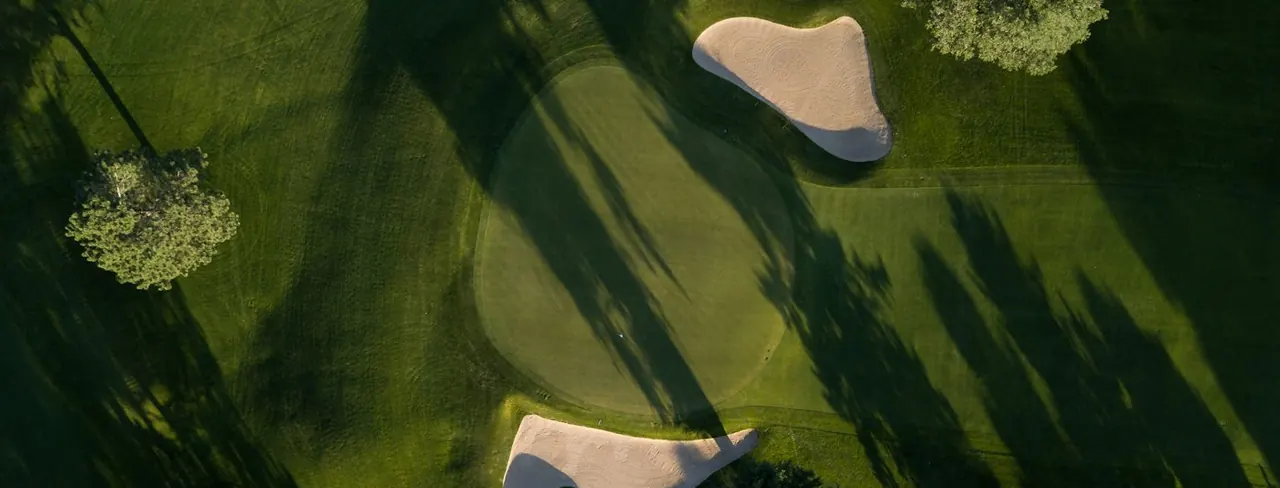 Aerial view of a green, bunkers and trees